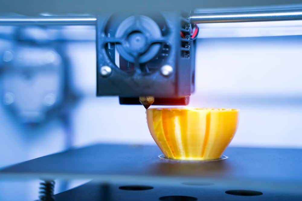 Impresora 3D doméstica imprimiendo figura en escritorio moderno